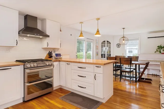 a kitchen with stainless steel appliances a stove a sink cabinets and wooden floor