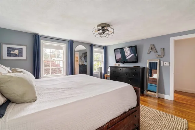 a spacious bedroom with a bed and a television