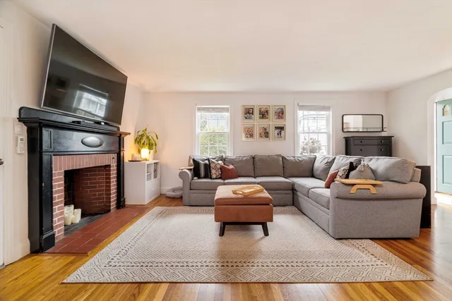 a living room with furniture a flat screen tv and a fireplace