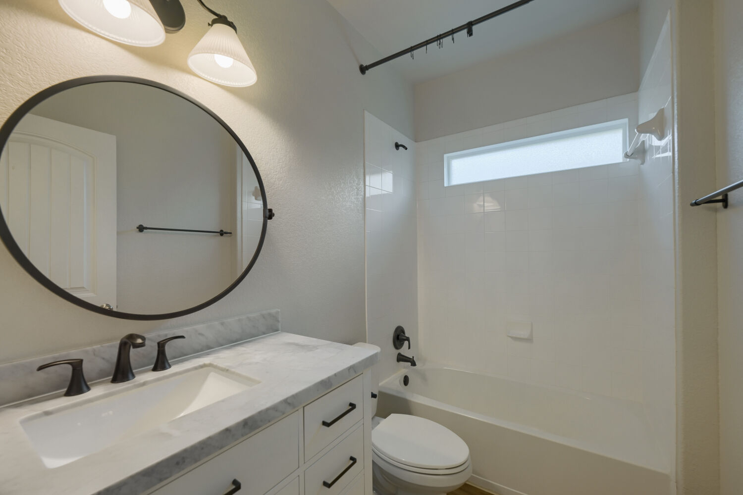 109 Moravia Road Georgetown, TX 78626 - Photo 21 of 25 A stone-topped vanity and a clean tiled tub shower define this modern space.