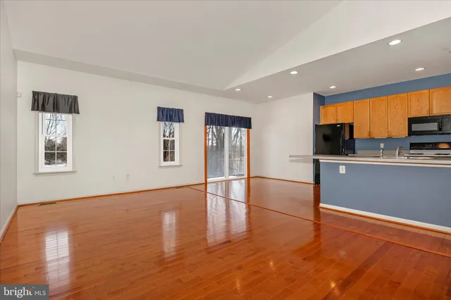 a view of an empty room with wooden floor