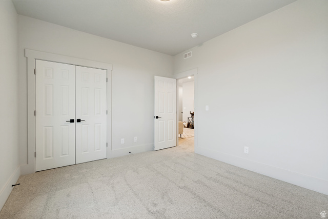 529 North Hvn Drive Mapleton, UT 84664 - Photo 28 of 30 Carpeted room featuring a double-door closet with black hardware, white baseboards, and light gray wall paint