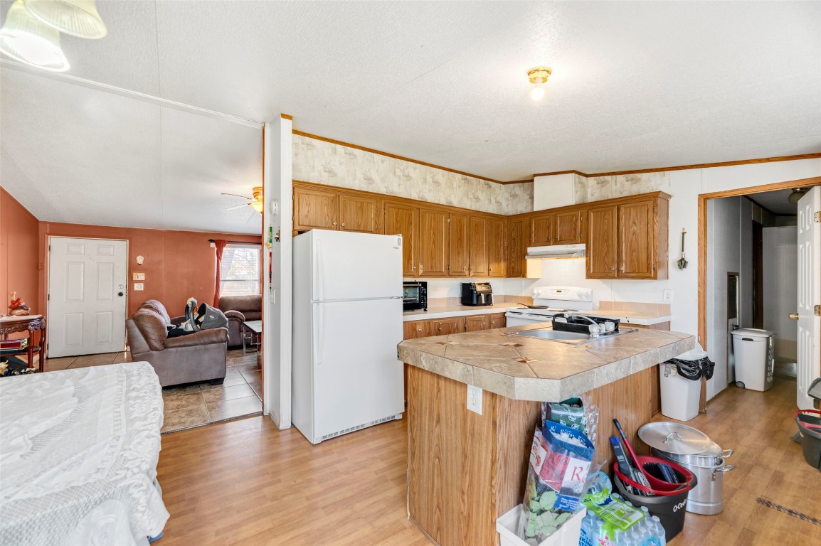 214 The Ranch Road Del Valle, TX 78617 - Photo 11 of 40 a kitchen with a refrigerator a stove and a dining table with wooden floor