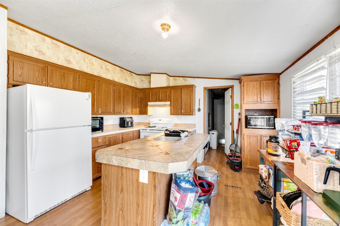 214 The Ranch Road Del Valle, TX 78617 - Photo 12 of 40 a open kitchen with stainless steel appliances granite countertop a refrigerator a sink dishwasher a dining table and chairs with wooden floor