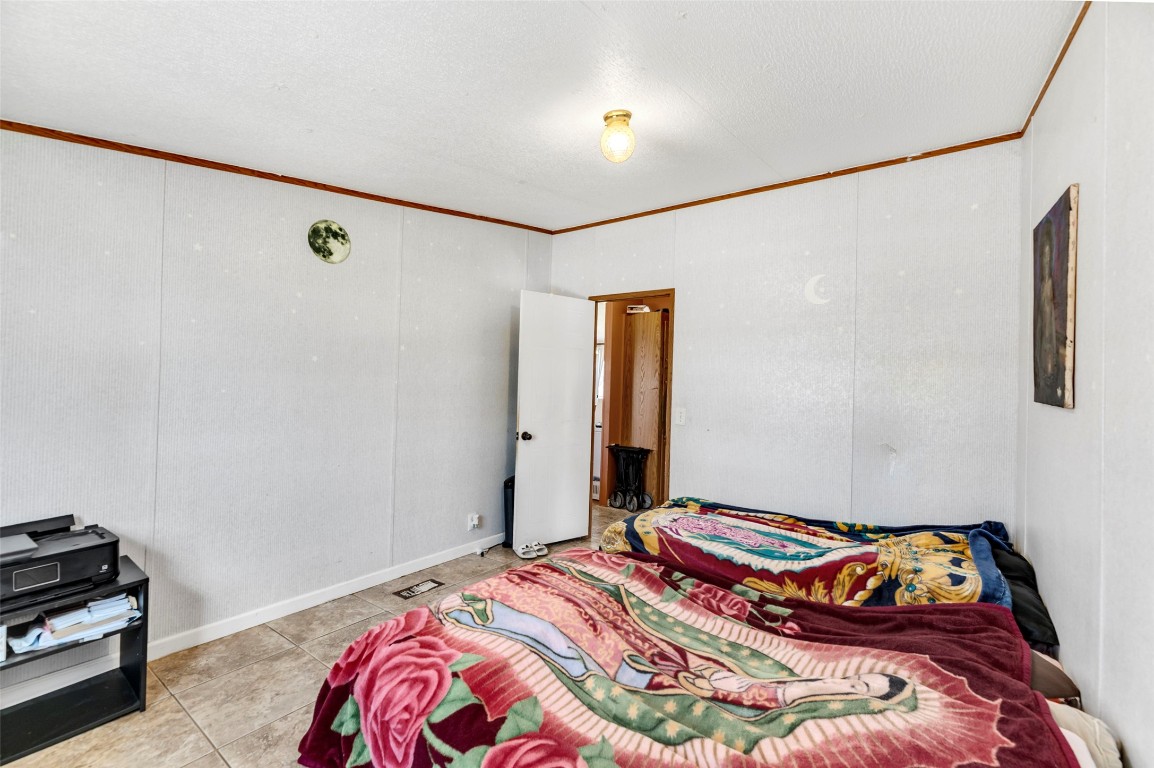 214 The Ranch Road Del Valle, TX 78617 - Photo 16 of 40 a bedroom with a bed and a potted plant