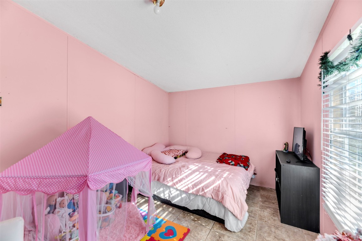 214 The Ranch Road Del Valle, TX 78617 - Photo 17 of 40 a bedroom with a bed and a couch