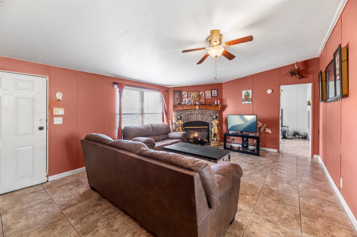 214 The Ranch Road Del Valle, TX 78617 - Photo 7 of 40 a living room with furniture a fireplace and a flat screen tv