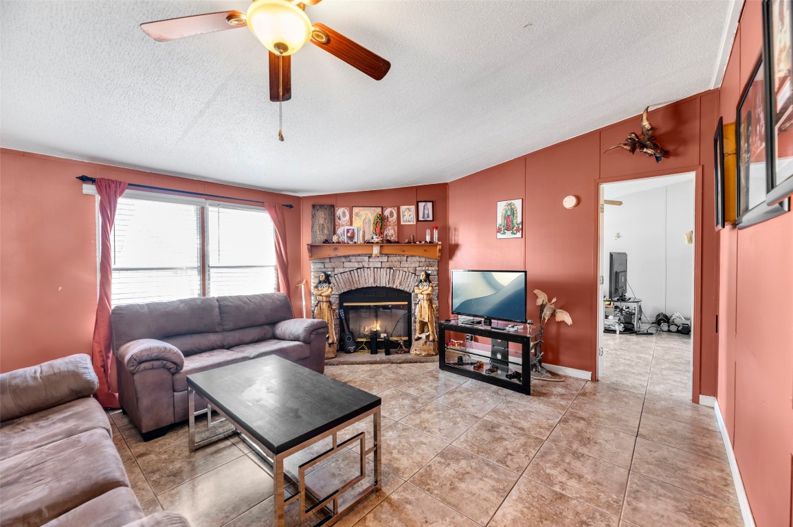 214 The Ranch Road Del Valle, TX 78617 - Photo 8 of 40 a living room with furniture a fireplace and a flat screen tv