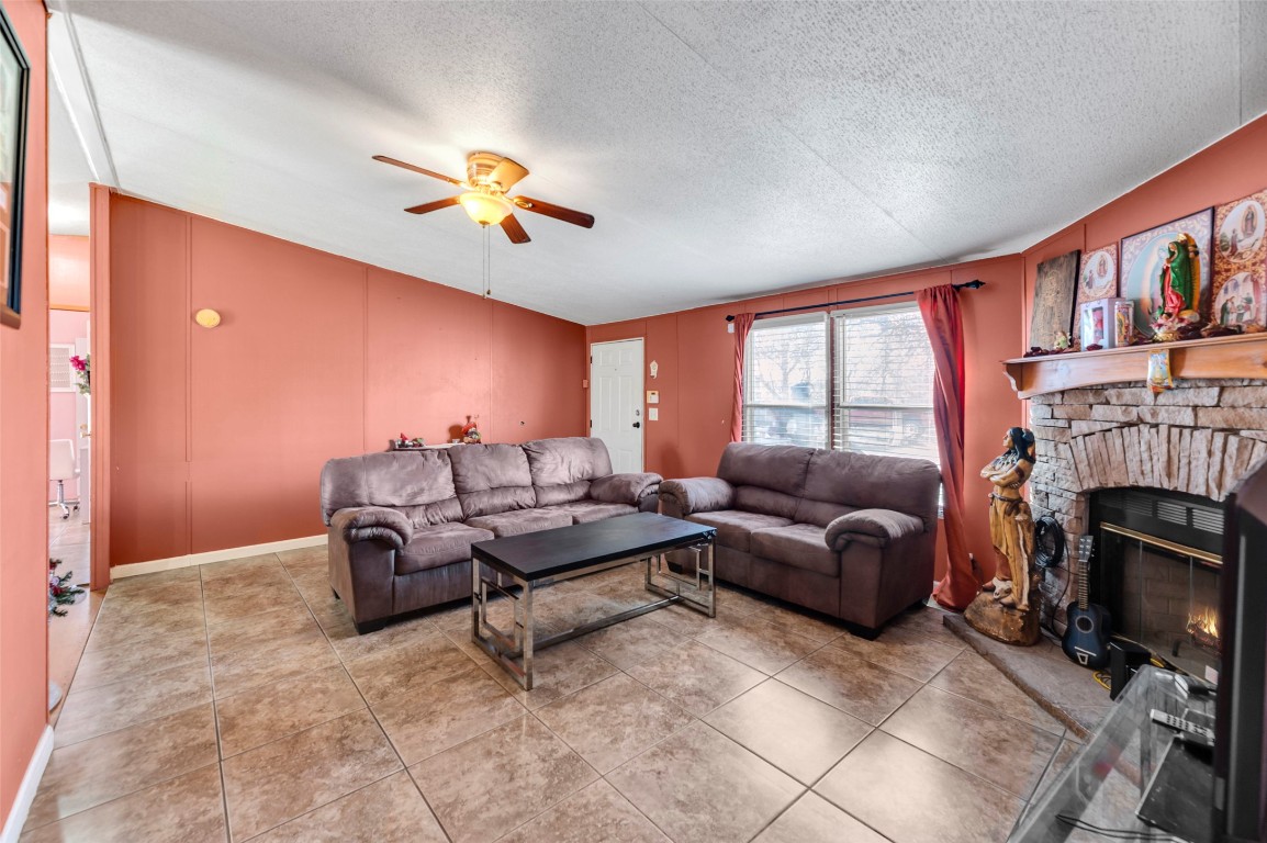 214 The Ranch Road Del Valle, TX 78617 - Photo 9 of 40 a living room with furniture a fireplace and a flat screen tv