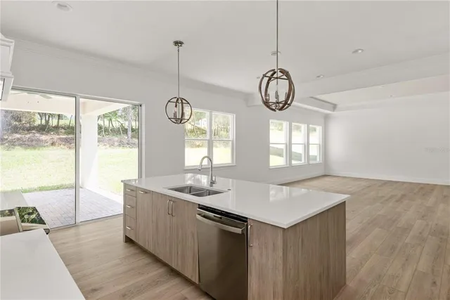 a kitchen with stainless steel appliances granite countertop a sink a stove and refrigerator