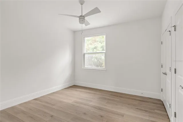 a view of a room with wooden floor and ceiling fan