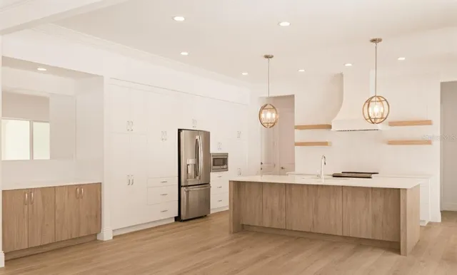 a kitchen with stainless steel appliances granite countertop a refrigerator a sink and a stove