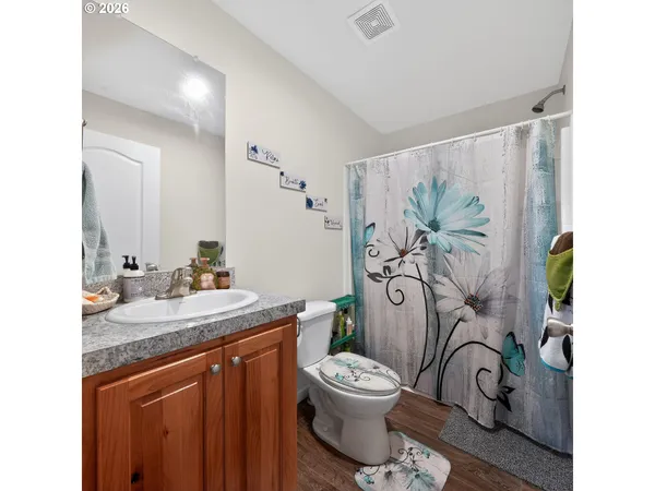a bathroom with a granite countertop sink toilet and shower