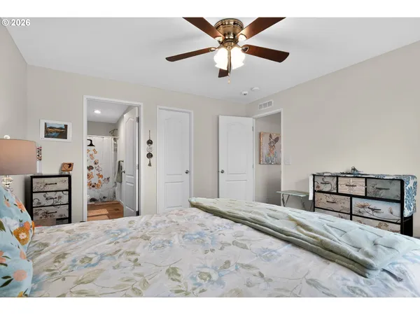 a bedroom with a bed and a flat tv screen on dresser