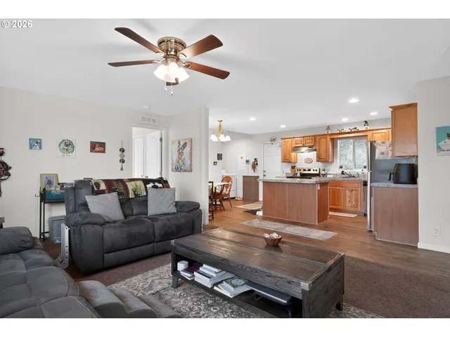 a living room with furniture kitchen view and a chandelier