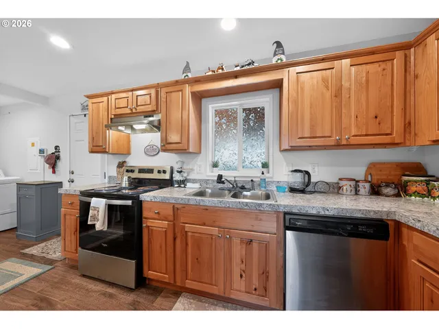 a kitchen with stainless steel appliances granite countertop a sink stove and cabinets