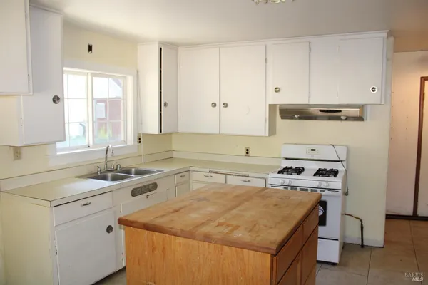 a kitchen with a sink stove and cabinets