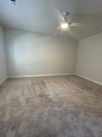 an empty room with a ceiling fan and a window