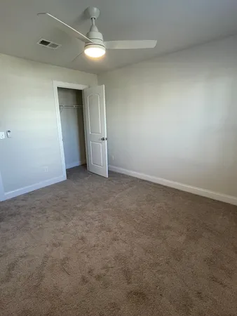 an empty room with closet and windows