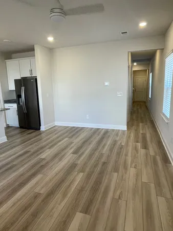 a view of an empty room with wooden floor