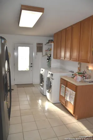 a view of a kitchen with fridge and window
