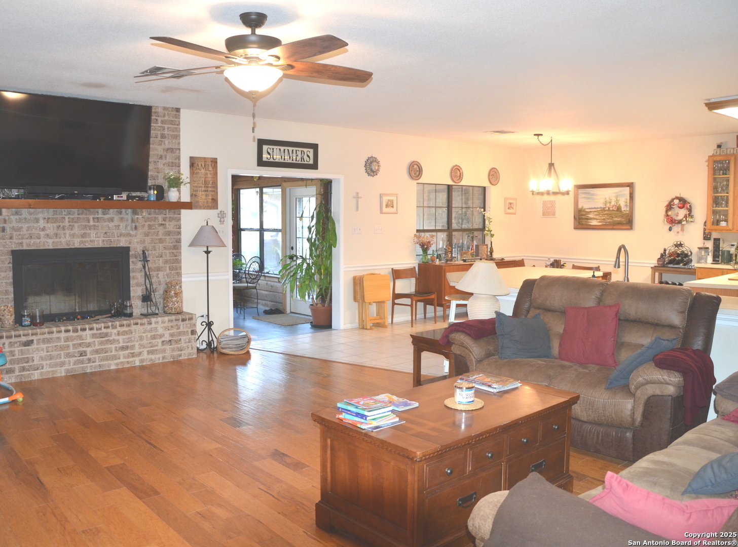 1219 County Road 761 Devine, TX 78016 - Photo 6 of 31 a living room with furniture a flat screen tv and a fireplace