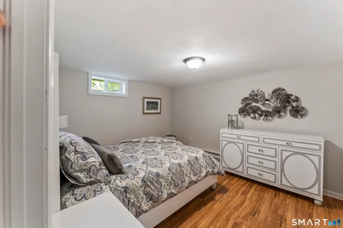 a bedroom with a large bed and wooden floor