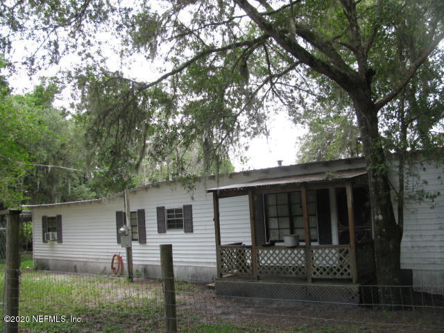 a view of house with yard and a tree