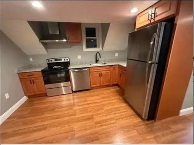 a kitchen with stainless steel appliances granite countertop a refrigerator stove and sink