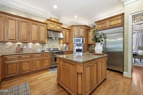 a kitchen with granite countertop a stainless steel stove and refrigerator