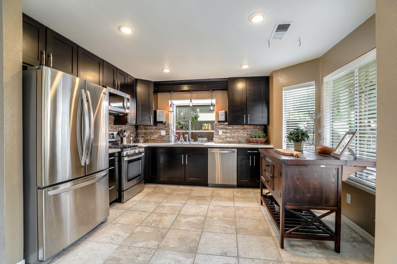 1645 Klipspringer Drive San Jose, CA 95124 - Photo 11 of 47 a kitchen with a refrigerator a sink a stove a dining table and chairs