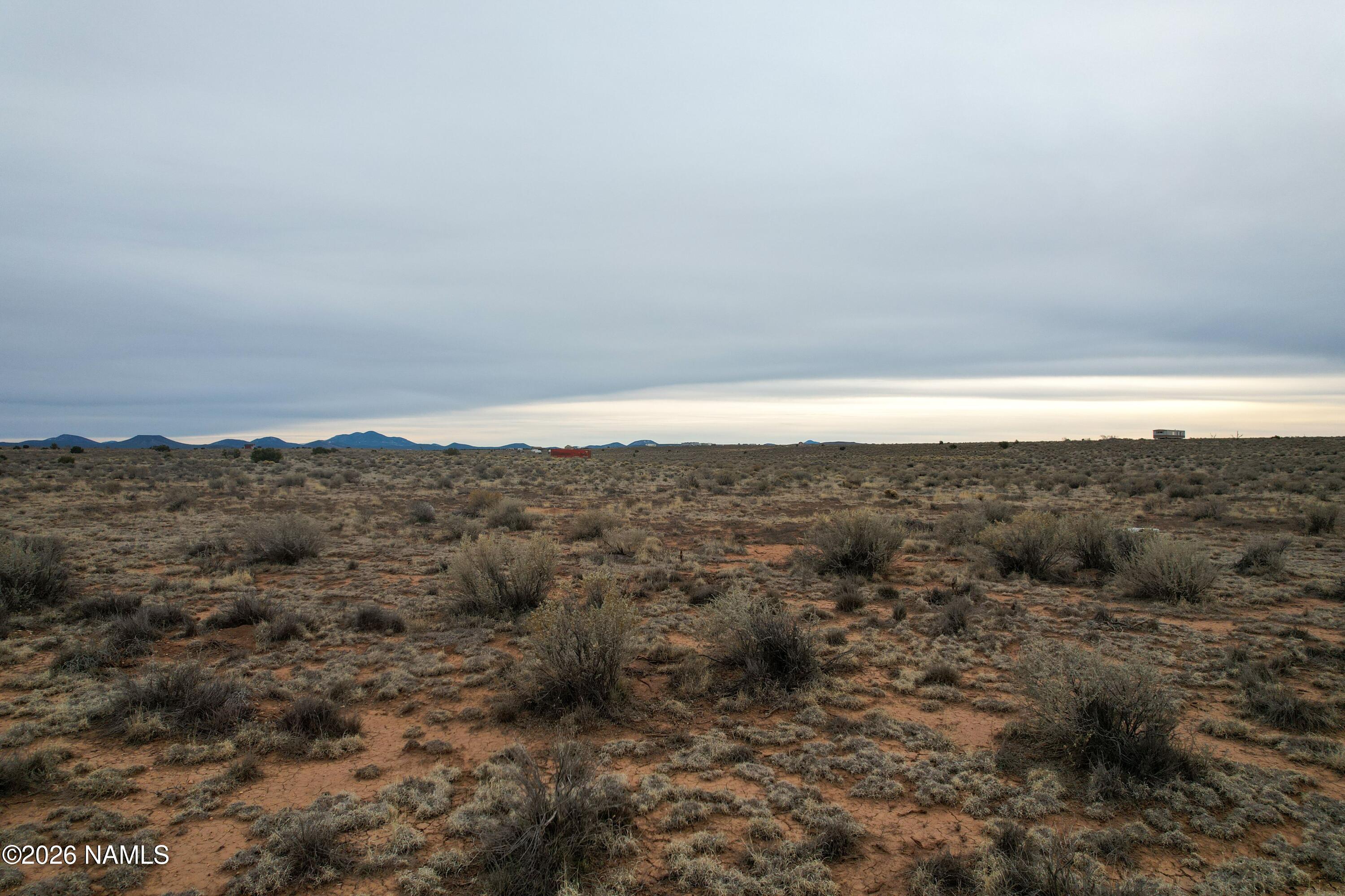 608 East Foothill Drive Williams, AZ 86046 - Photo 4 of 7 a view of a dry yard with mountains in the background