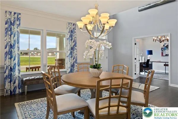 a view of a dining room with furniture a chandelier and a window