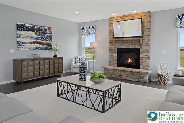 a living room with furniture a flat screen tv and a fireplace