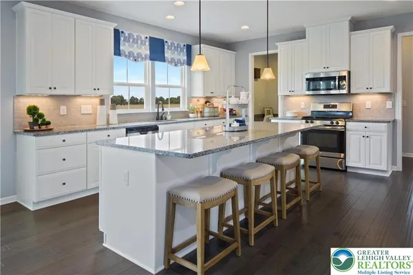 a kitchen with stainless steel appliances granite countertop a stove top oven a sink a counter space and cabinets