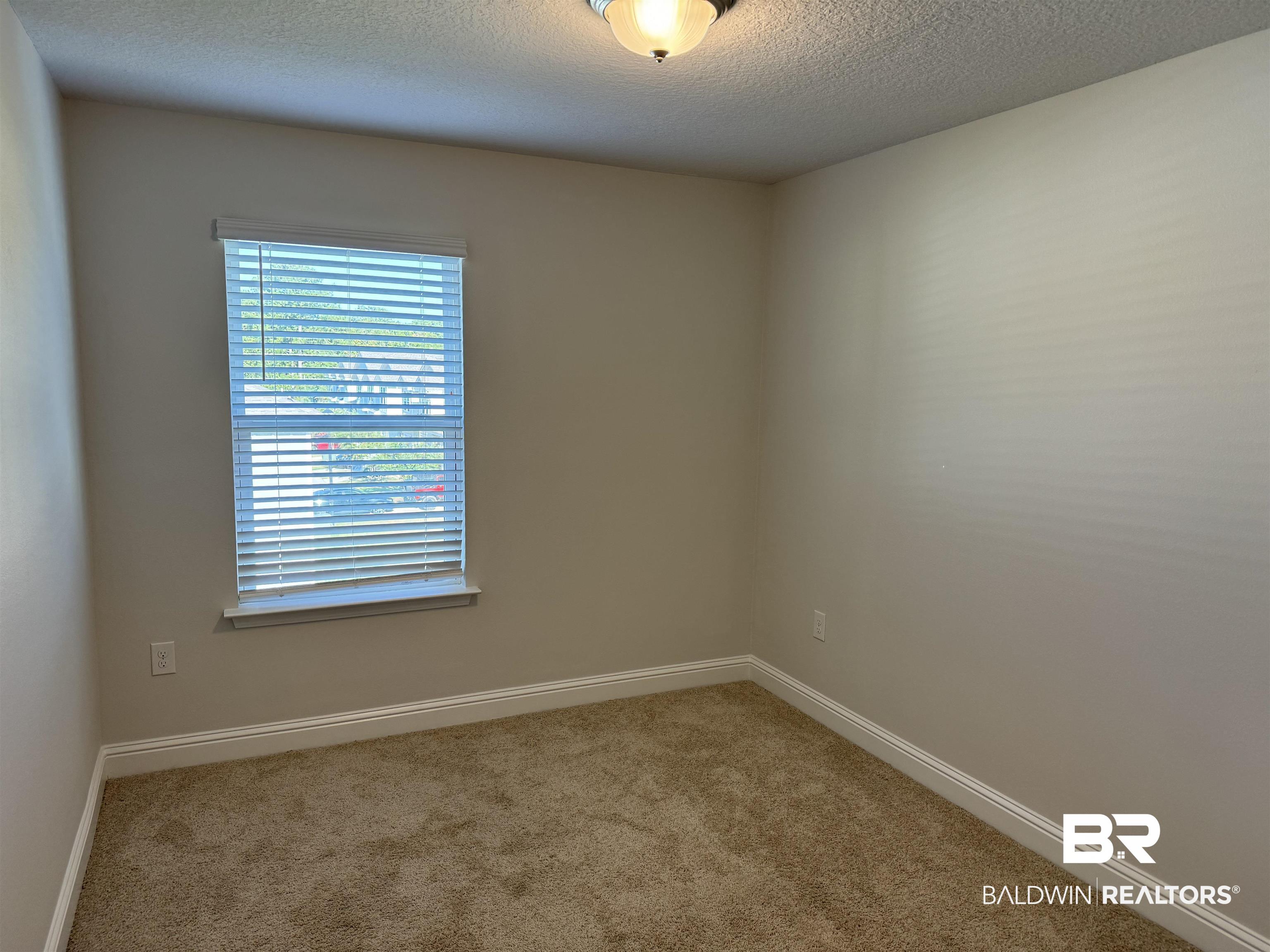 25806 Pollard Road, Unit 42 Daphne, AL 36526 - Photo 17 of 21 Carpeted empty room featuring a textured ceiling