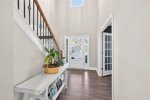 a kitchen with stainless steel appliances kitchen island granite countertop a refrigerator a stove a sink dishwasher and wooden cabinets with wooden floor