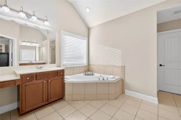 a spacious bedroom with a bed and a flat screen tv