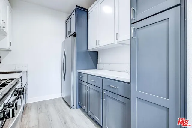 a kitchen with stainless steel appliances granite countertop a refrigerator and a stove top oven