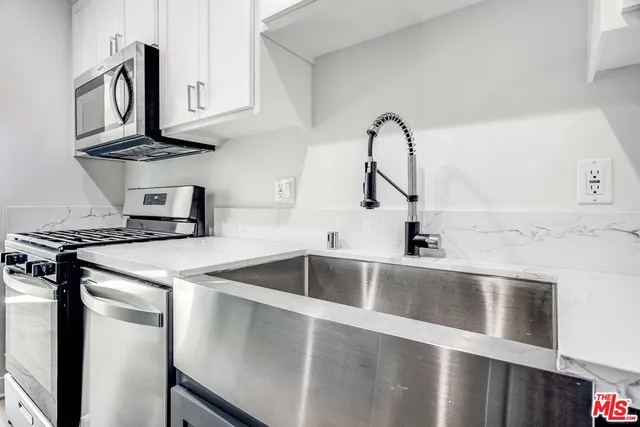 a kitchen with stainless steel appliances granite countertop a sink and a stove top oven with granite countertops