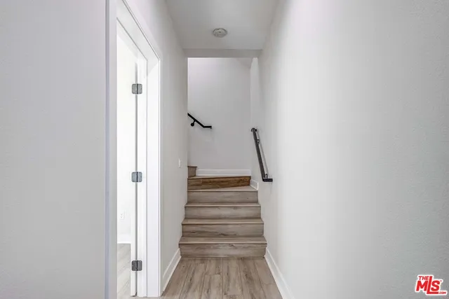 a view of a hallway with wooden floor and entryway