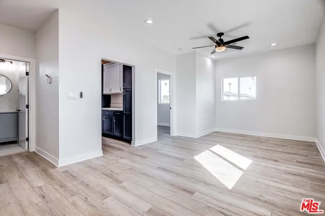 a view of empty room with wooden floor and window