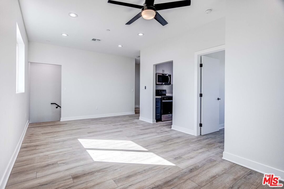 624 West 83rd Street, Unit 624 Los Angeles, CA 90044 - Photo 9 of 26 a view of a livingroom with a hardwood floor and a ceiling fan