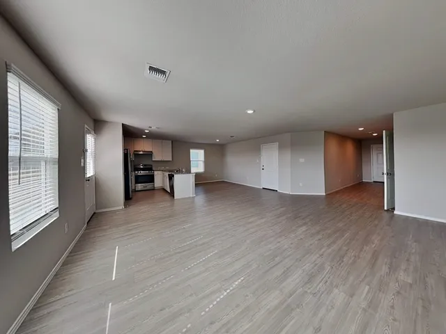 a view of empty room with wooden floor