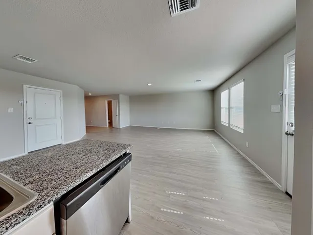 a living room with stainless steel appliances granite countertop furniture and a refrigerator