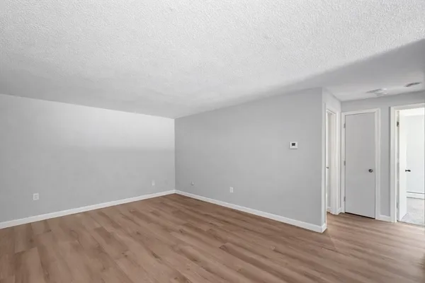a view of an empty room with wooden floor