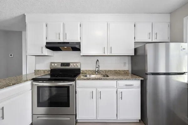 a kitchen with appliances a sink and cabinets