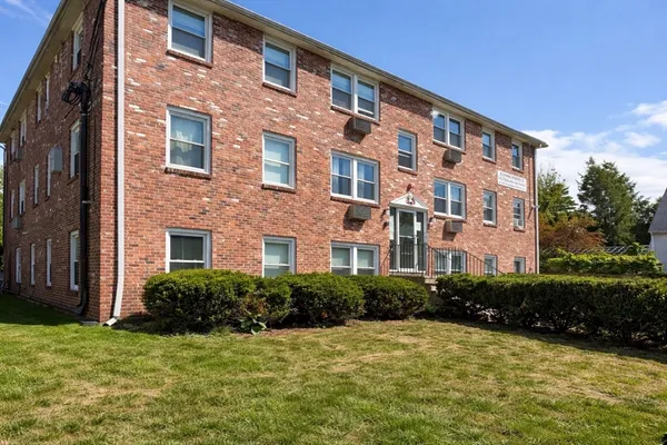 a front view of a building with a yard