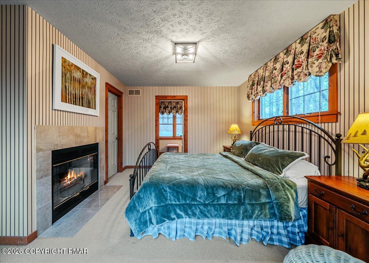 723 Lower Deer Valley Road Tannersville, PA 18372 - Photo 27 of 58 a bedroom with a bed and a fireplace