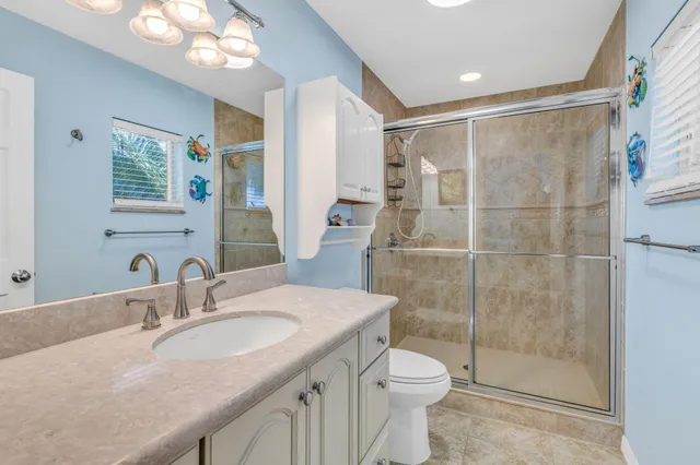 a bathroom with a granite countertop sink toilet and shower
